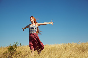 redhead woman in a dress outdoors