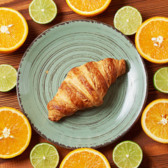 Food plate of Citrus mix  and croissant on wooden background