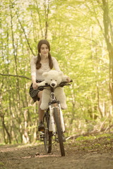 fun girl with teddy bear on bike in sunny park, toned image