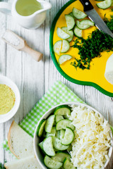  vegetarian Healthy food, light, low calorie fitness salad of fresh cucumbers, cabbage and dill with olive or sunflower oil, spices and salt on a light wooden background 