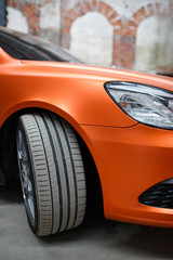Orange car with alloy wheel indoor