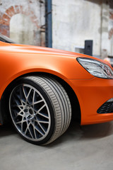 Orange car with alloy wheel indoor