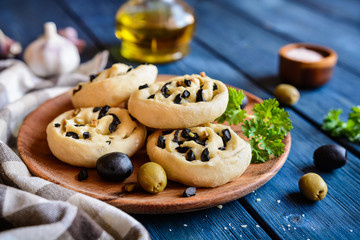 Baked bread rolls filled with chopped olives and garlic