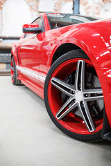 Red car with alloy wheel indoor