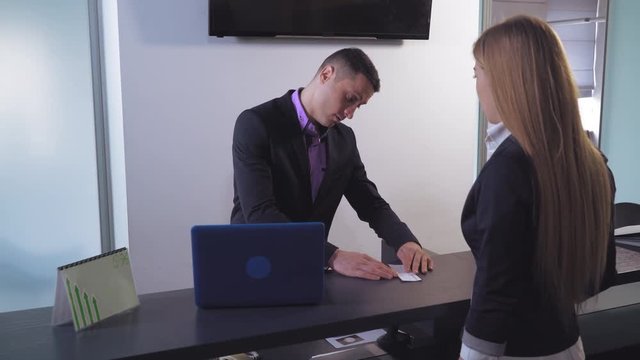 Woman client standing dear working place bank clerk. Attractive businesswoman giving worker check man count money and give female.