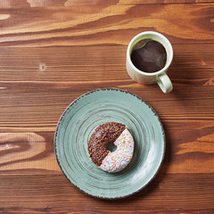food plate of donut and croissant with mug of coffe on wooden background