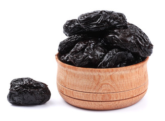 Dried plums - prunes in wooden bowl isolated on white background