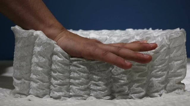 Orthopedic sample of a mattress with springs compressed by hand