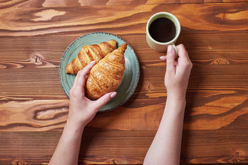 food plate of donut and croissant with mug of coffe on wooden background