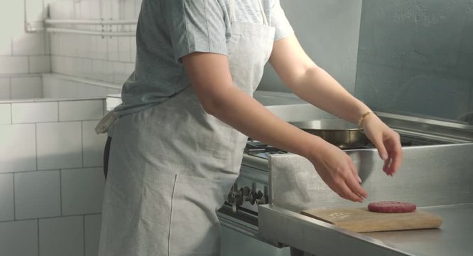 Woman cooking hamburger in the kitchen