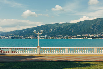 Embankment at the sea shore against the backdrop of picturesque mountains walking along the waterfront concept