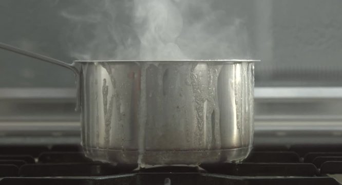 zoom close up of burned milk on pot and a steam from it