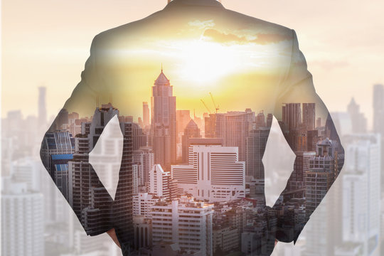 Double Exposure Of A Back Turned Businessman, Urban And City At The Sunset As Business And Vision Of Leader Concept.