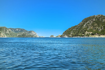 Fototapeta na wymiar Summer touristic trip on Aegean sea: blue water and sky, green mountains