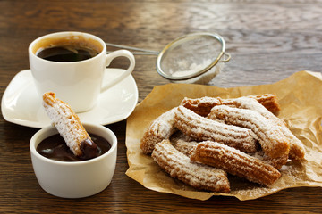 Churros with hot chocolate and powdered sugar.
