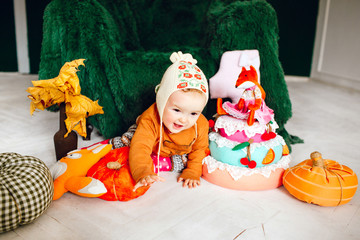 Little child crawls before large green armchair