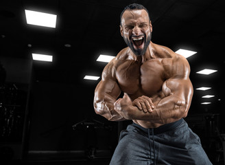 Plakat Adult guy bodybuilder posing in gym
