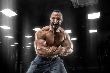 Obraz na płótnie Canvas Adult guy bodybuilder posing in gym