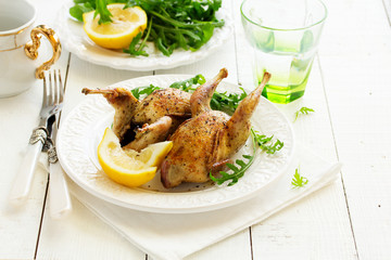 Delicious fried quail with herbs and greens.