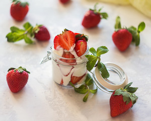Homemade yogurt with fresh strawberries on a white background