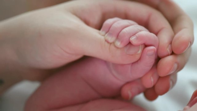 Father and mother holding newborn baby hand. 4K UHD video 3840X2160