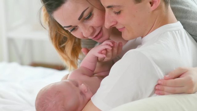 Happy young family. Father, mother and their newborn baby. Parenthood concept. 3840X2160 4K UHD video 