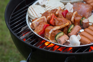 Fleisch und Gemüse auf Kugelgrill, glühende Kohle, Grillsaison