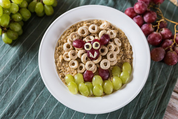 Oatmeal porridge with a funny grape decoration