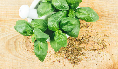 Raw green basil and dried, on the wooden table.