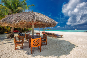 Table and chairs at the beach on tropical island in Indian ocean, Maldives