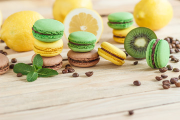 Green and yellow french macarons with kiwi, lemon and mint decorations