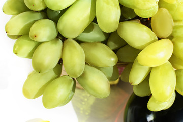 Berries of green grapes and a bottle of wine