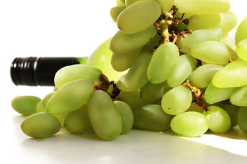 Berries of green grapes and a bottle of wine