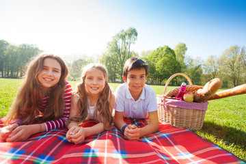 Kids laying on the picnic blanket in summertime