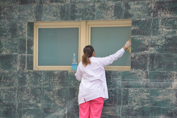 mujer limpiando cristales