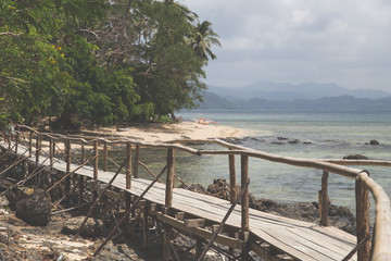 Obraz premium Long wooden bridge in beautiful tropical island beach - Philippines, the island of Palawan, next to El Nido.