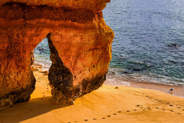 beautiful Atlantic ocean view horizon with sandy beach,  rocks and waves. Algarve,  Portugal