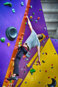 Climber On Artificial Climbing Wall In Bouldering Gym Without Insurance.