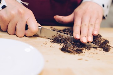 Cafe employee cuts the chocolate into small pieces.
