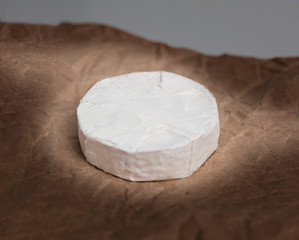 Fresh Camembert cheese is a natural, on Kraft paper