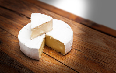 French Camembert cheese on rustic wooden background