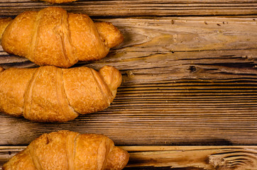 Fresh croissants on wooden table. Top view
