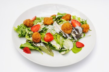 Salad with strawberry meat, meatballs and greens close-up on a white background