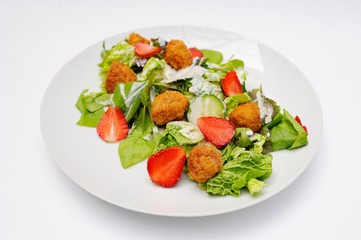 Salad with strawberry meat, meatballs and greens close-up on a white background