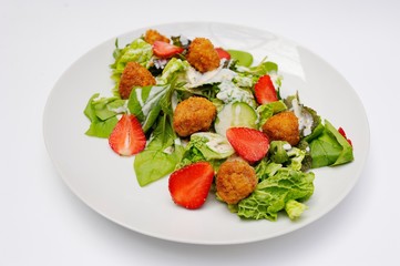 Salad with strawberry meat, meatballs and greens close-up on a white background