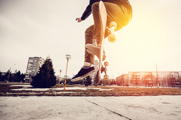 Man young skateboarder legs skateboarding at skatepark On Sunset. Concept tricks and jumping on a skateboard © Parilov