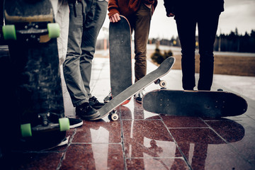 male skateboarder man holds a skate board in his hand against the background of a team of friends....