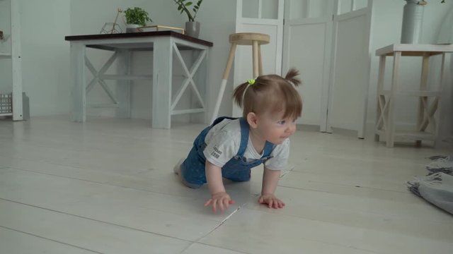Adorable smiling baby crawling on floor towards the camera