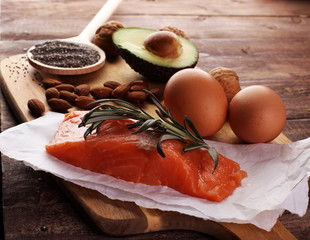 Selection of healthy fat sources, rustic background. Healthy eating, diet concept with salomon and avocado