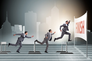 Businessman jumping over barriers in business concept